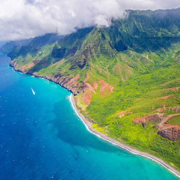 aerial view of a tropical Hawaiian beach bordered by lush mountains